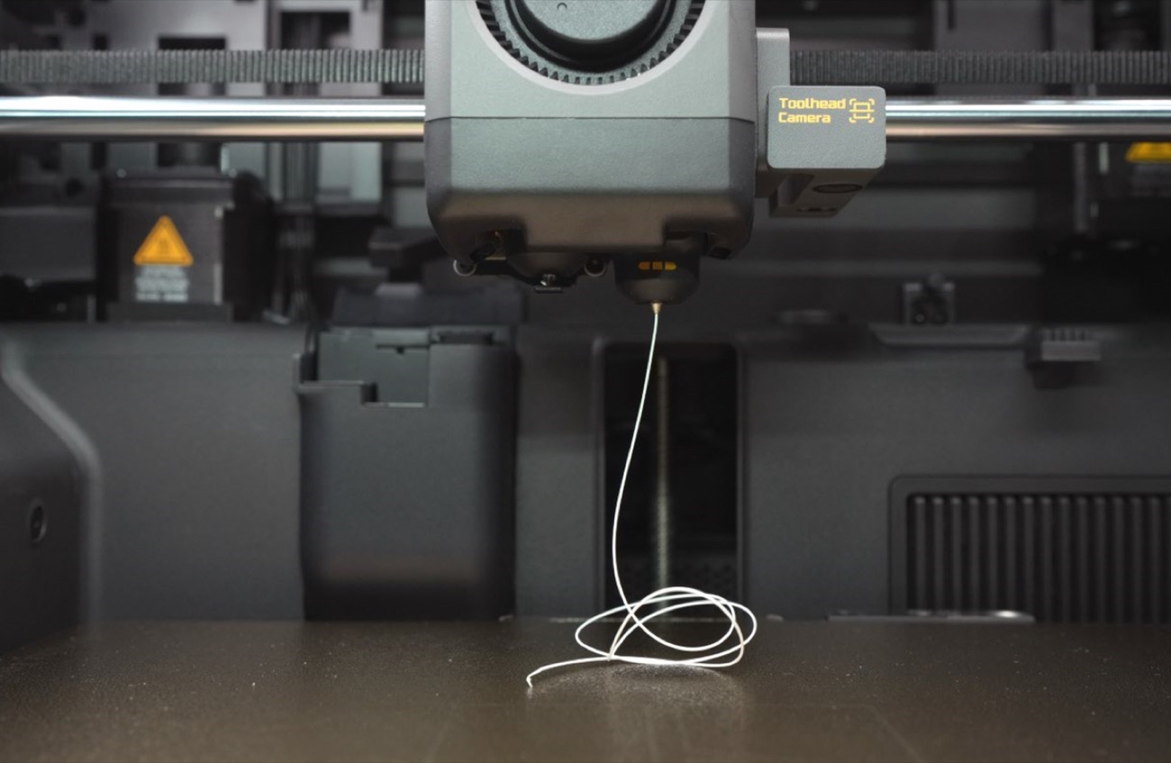 Extrusion test on the X2D with filament coming out of the nozzle as a thin strand