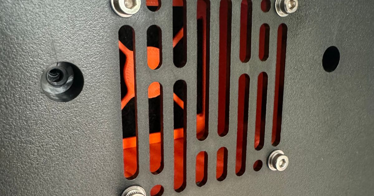 Orange printed filter housing behind the Q1 Pro rear panel grille