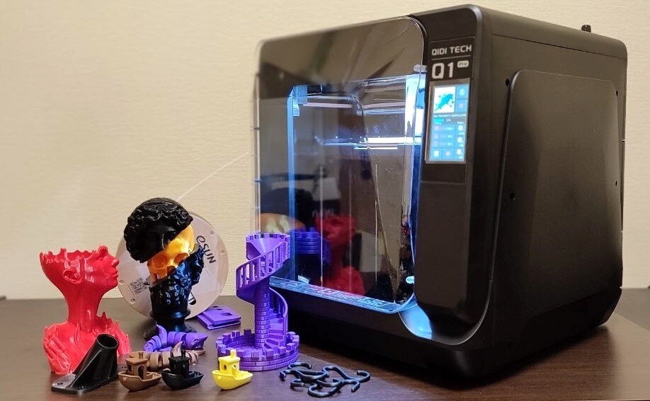 QIDI Q1 Pro next to parts printed on it