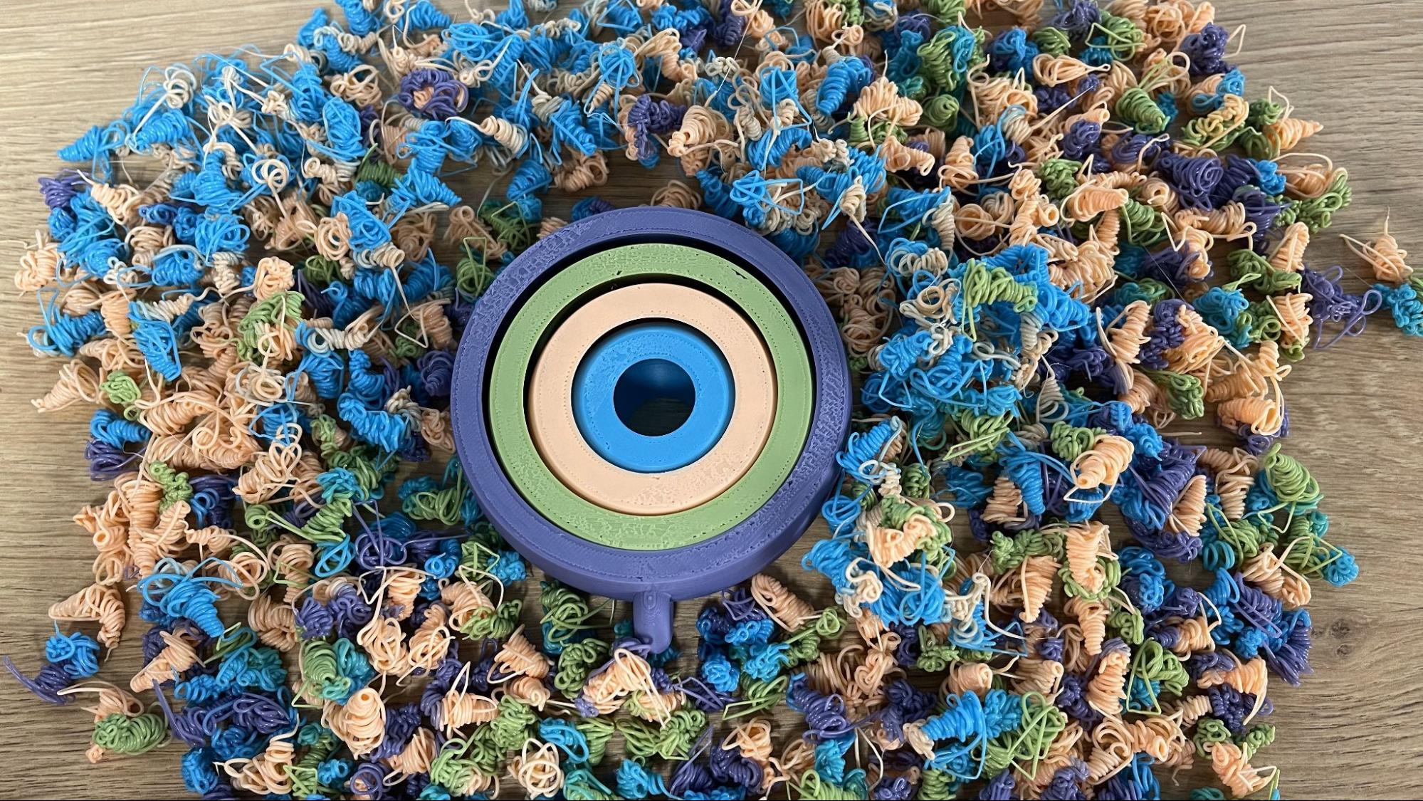 A multicolor spinner surrounded by a large pile of purge waste