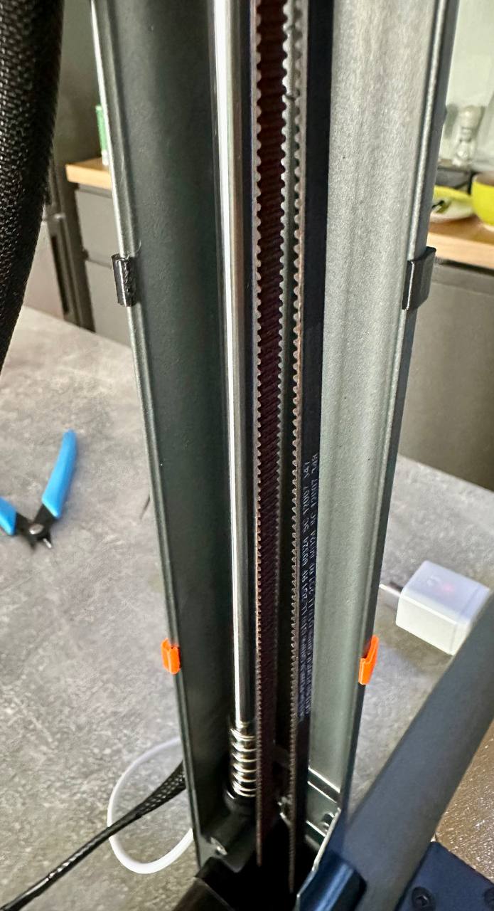 Printed clips on the Ender-3 V3 CoreXZ column holding wires alongside the Z belt
