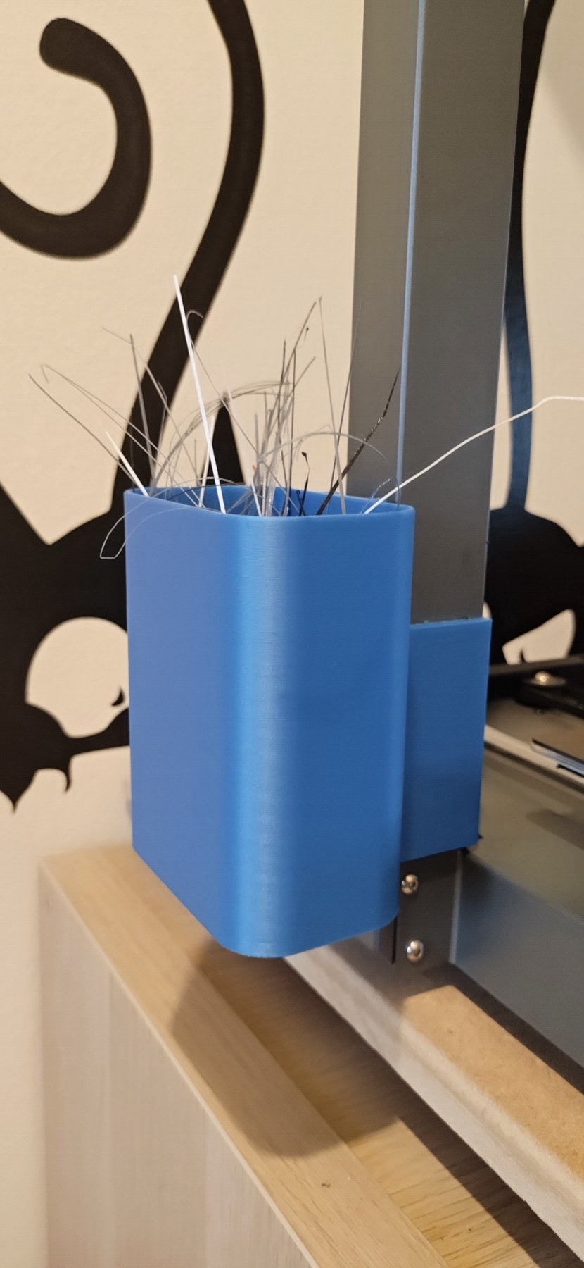 Blue printed filament trash bin mounted on an Ender-3 V3 frame