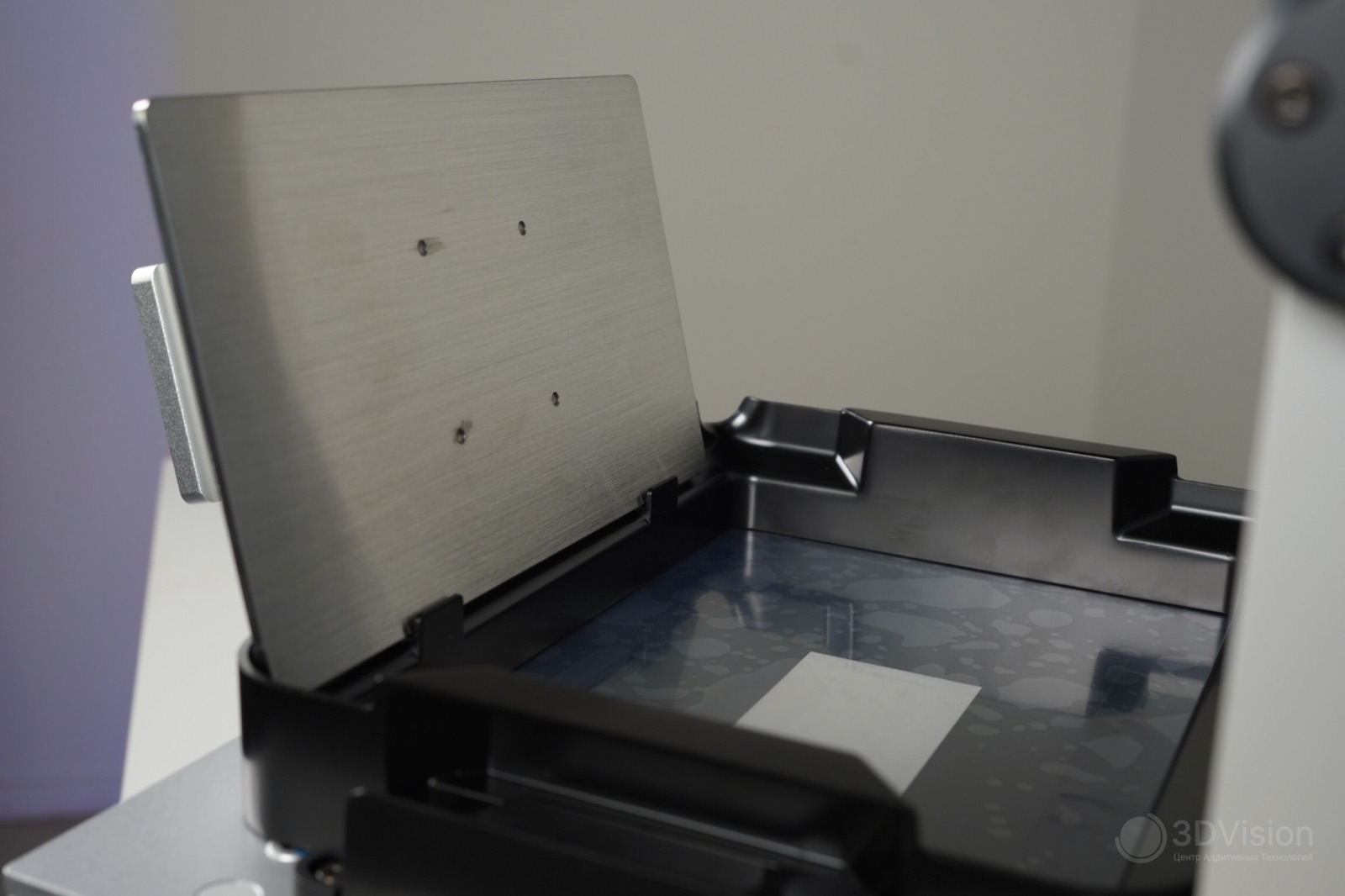 Платформа Anycubic Photon P1 в держателях ванны для стекания фотополимера; на нижней стороне видны четыре крепёжных отверстия