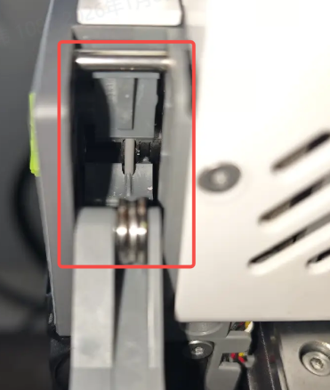 SPARKX i7 extruder drive gear close-up in red box — filament shavings on the teeth