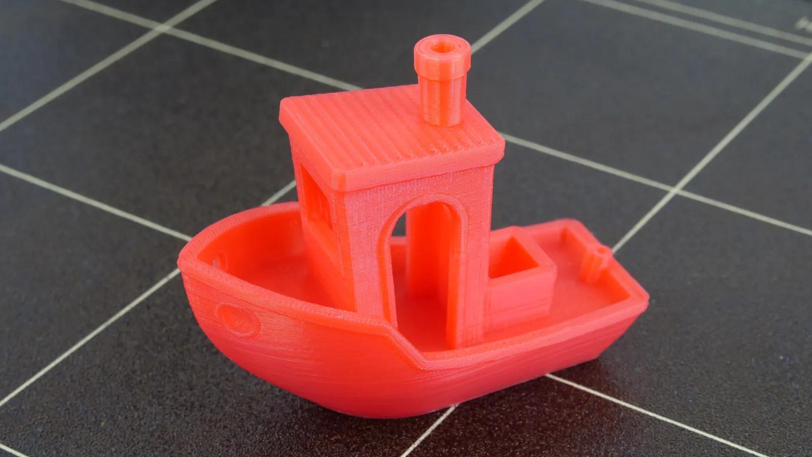 3DBenchy — красный тестовый кораблик на столе принтера