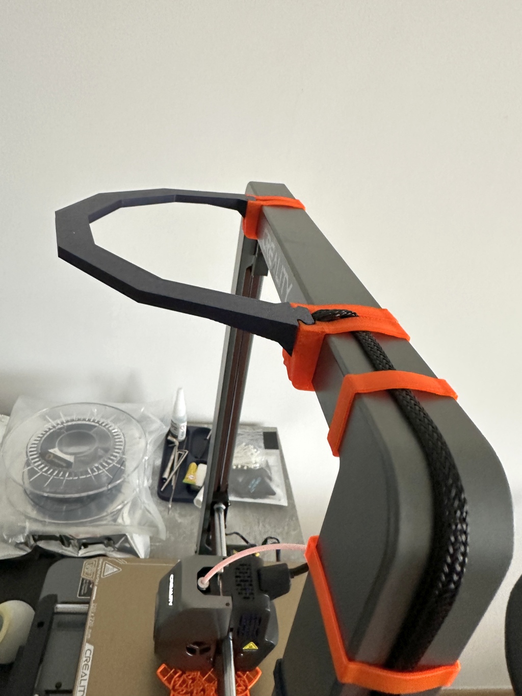 Orange printed clips on an Ender-3 V3 CoreXZ gantry holding an LED strip mount