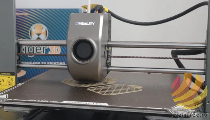 Печатающая головка Ender-3 V3 над большой моделью на столе — пример длительной печати, на которой перехлёст филамента критичен