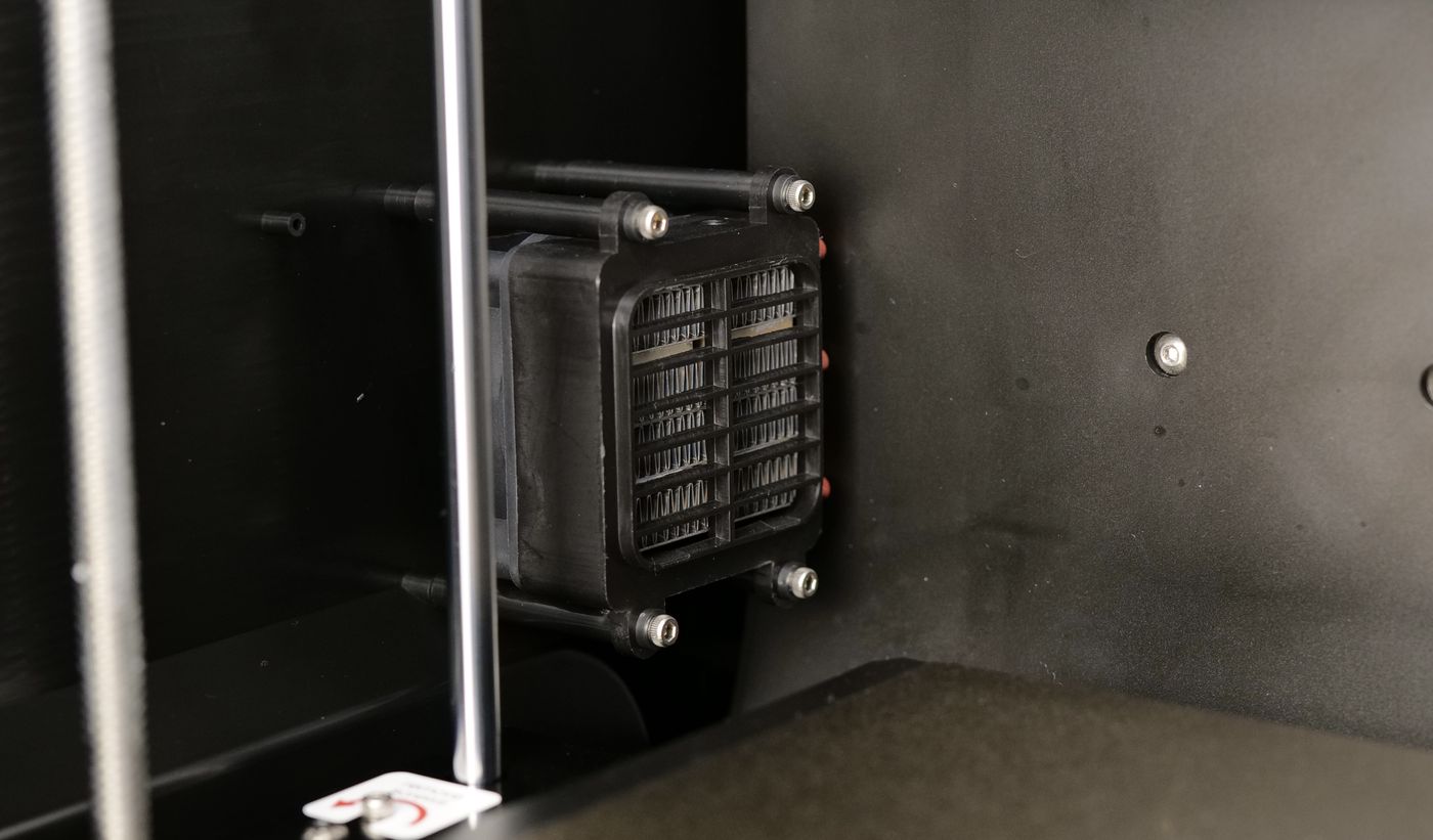 QIDI Q1 Pro chamber heater with an open grille on the rear wall — contacts under 230 V mains