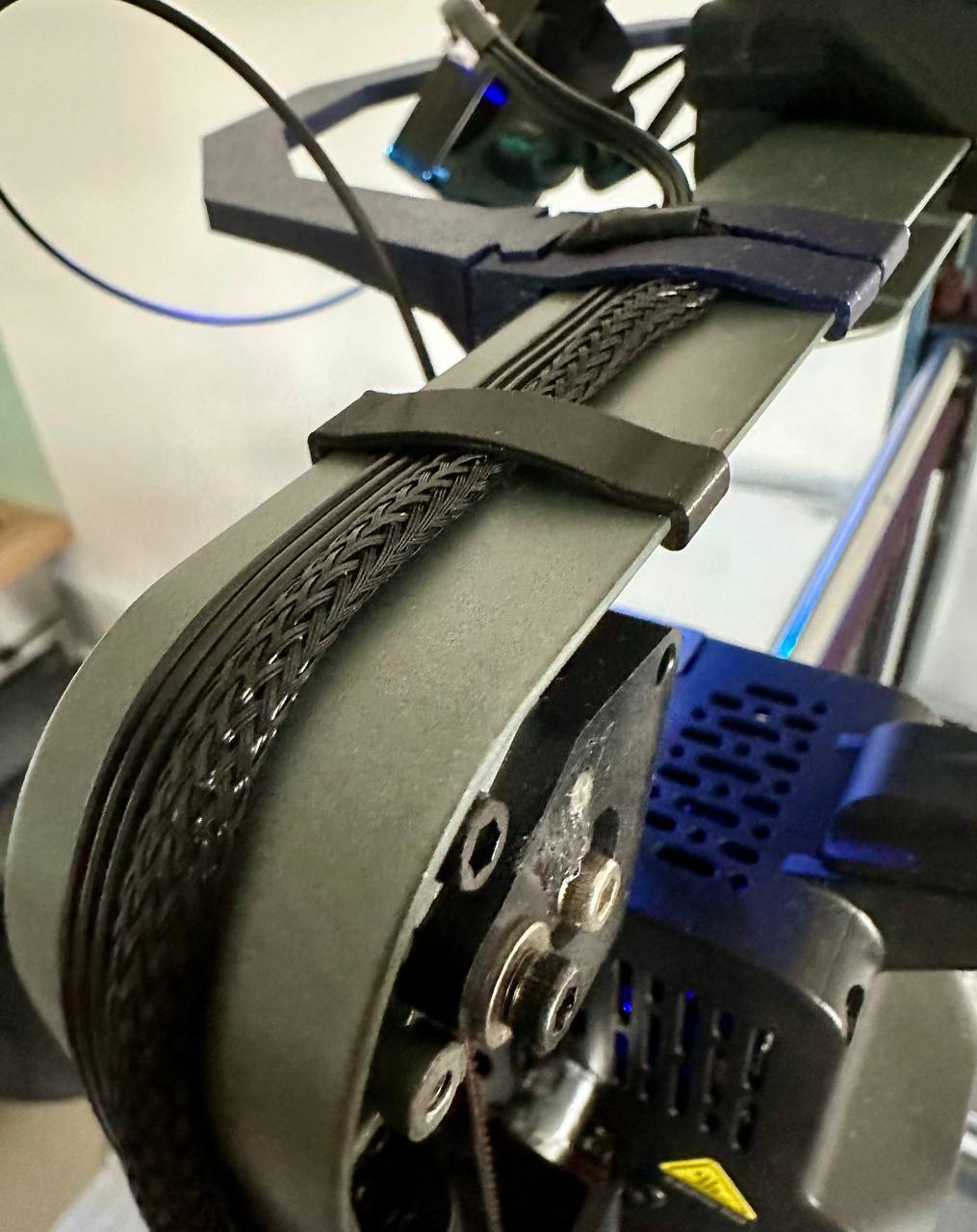 Clips pressing the sleeved harness against the top gantry beam of an Ender-3 V3