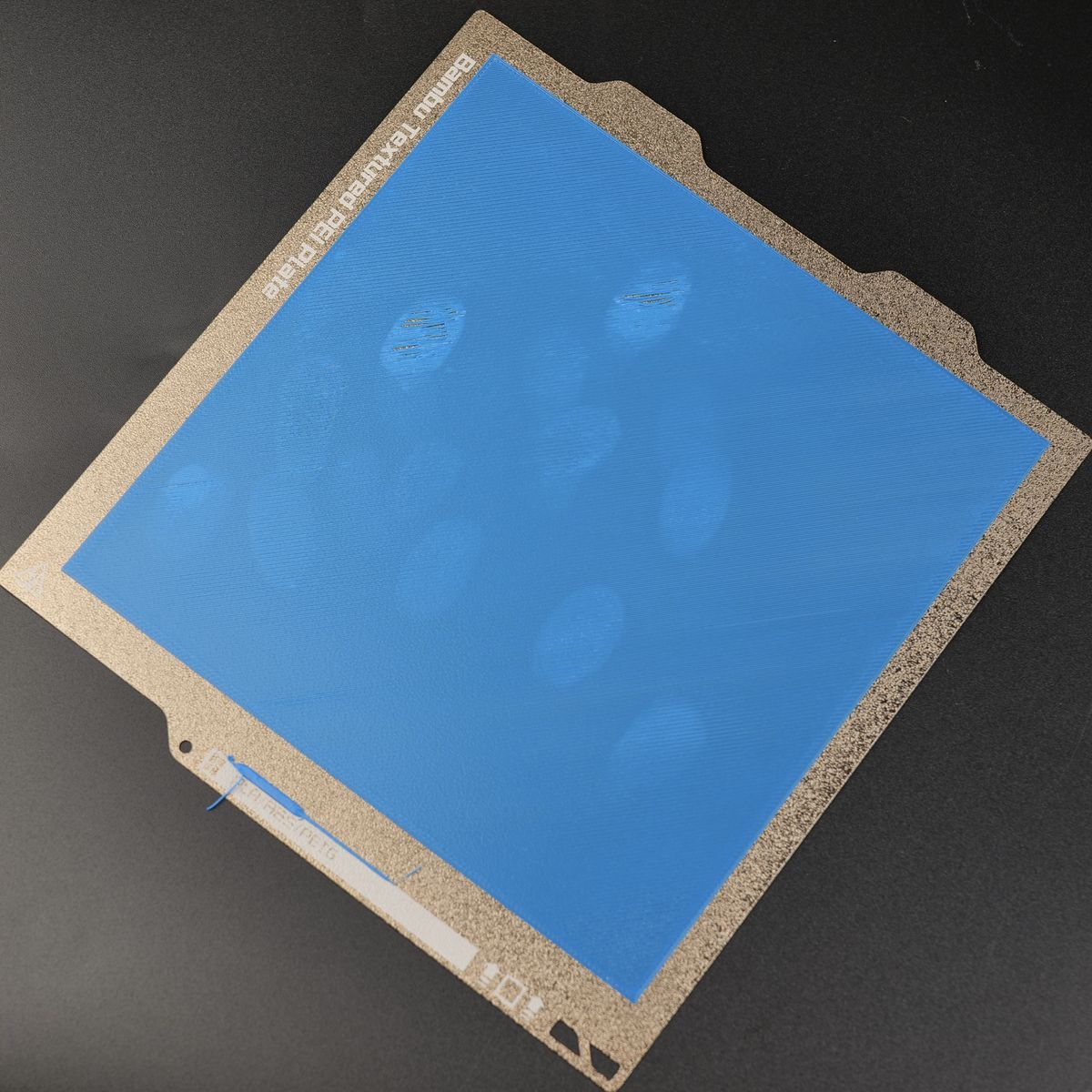 Textured PEI plate with oil marks — adhesion loss cause