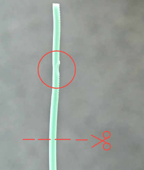 Filament tip with defects — teeth marks and abrasion on one side, sign of slipping