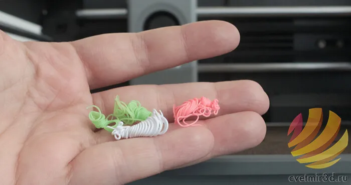 Отходы пластика от смен цвета — обрезки филамента в руке