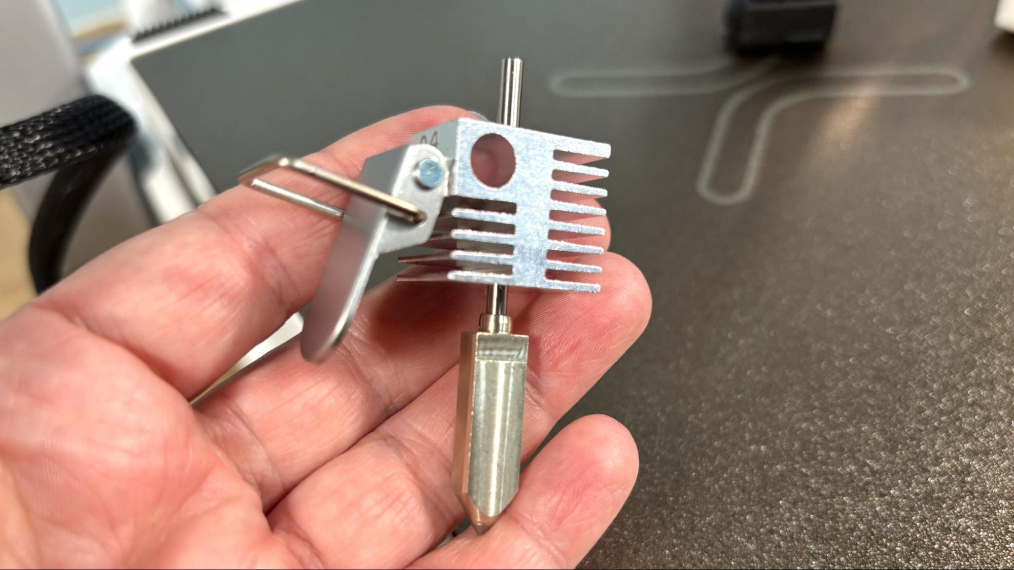 SPARKX i7 quick-release hotend with side latch — held in hand, removed from printer