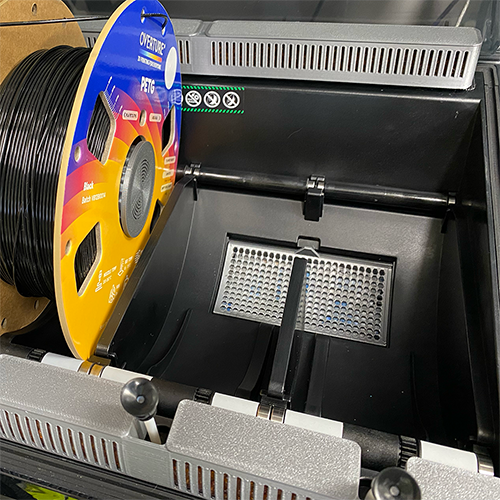 Printed desiccant box with silica gel installed inside open Creality K2 Plus CFS with PETG spool